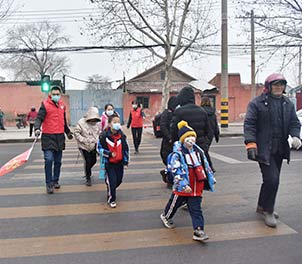 赢博(中国)青年文明号义务指挥交通，为学生上学安全保驾护航